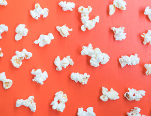 Salted popcorn on the orange paper cardboard