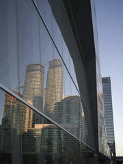 Low angle view of glass building exterior with reflection of skyscrapers, Toronto, Ontario, Canada