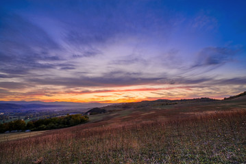 Naklejka na ściany i meble Romantic, bright and colorful sunset over a mountain range in Transilvania. Beautiful, colorful autumn background