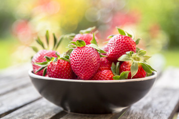 Bowl of strawberries on wooden garden table