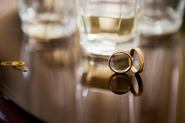 Wedding rings on the table. Reflection from the glass