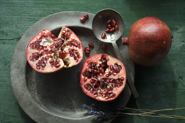 Two halves of pomegranate on tin plate