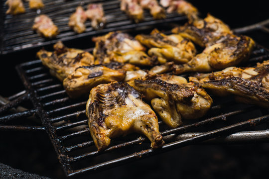Half-sliced chickens grilling