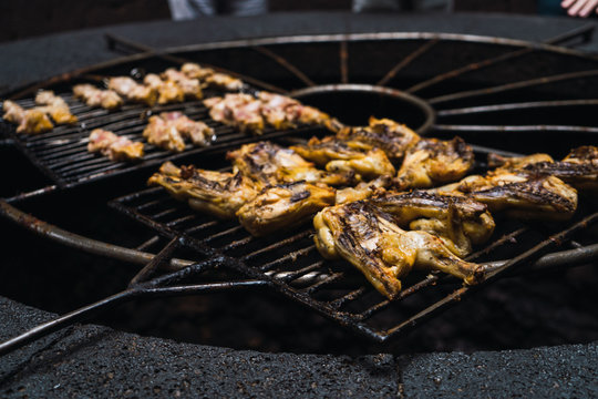 Half-sliced chickens grilling
