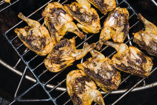 Half-sliced chickens grilling