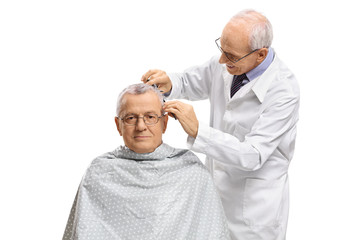 Fototapeta premium Mature man with a barber cutting his hair