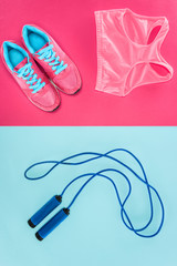 Sports equipment with shoes, skipping rope and sports top isolated on pink and blue
