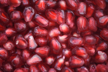 close up macro food photography image of shiny juicy red fruit pomegranate seeds for an abstract background image 