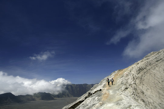 Indonesia, Java, Travelers hiking on crater rim of Mount Bromo