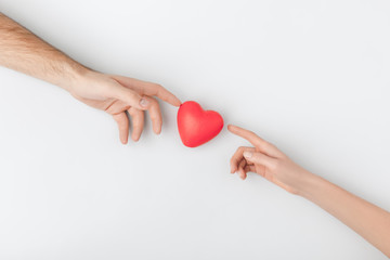 top view of hands touching red heart isolated on white background