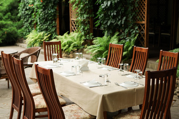 Street restaurant in the summer. Wooden chairs and table served with dishes