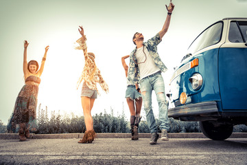 Happy friends driving a vintage minivan