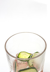 Close up of icy cold gin and tonic with cucumber, rim of glass