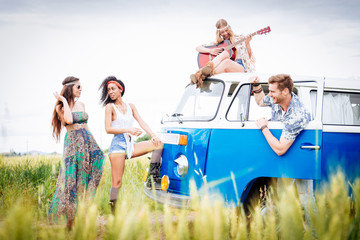 Obraz premium Happy friends driving a vintage minivan