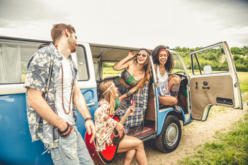 Happy friends driving a vintage minivan