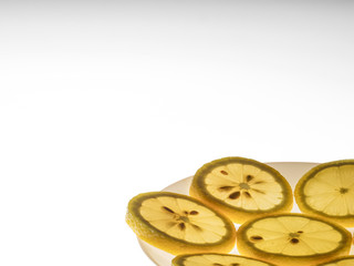 The sliced lemon on white plate on bright lightened background design for background and presentation slide