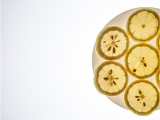 The sliced lemon on white plate on bright lightened background design for background and presentation slide
