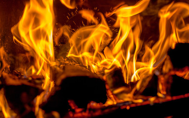 In the fireplace a hot red fire burns brightly on a dark background_
