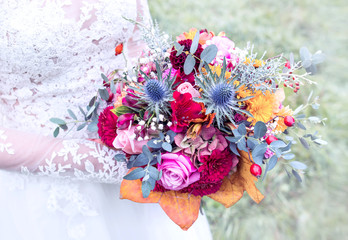 colorful wedding bouquet in bride hand with lacy white wedding dress detail