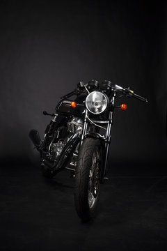 Motorrad caferacer im studio vor schwarzem hintergrund
