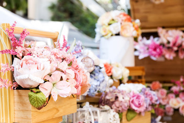 Artificial flower in the pot over wood table