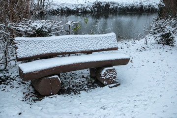 Parkbank im Winter mit Schnee bedeckt
