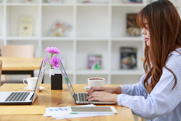 Freelancing woman using laptop computer for distance job while sitting in coffee shop. Business woman typing on laptop at workplace Woman working in home office hand keyboard.