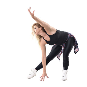 Sweaty woman aerobics instructor dancing jazz dance in bending posture. Full body length portrait isolated on white background. 