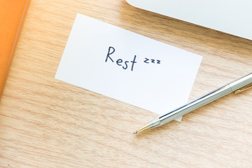 Workplace top view of  Wooden desktop with laptop, notebook and paper note for break time concept