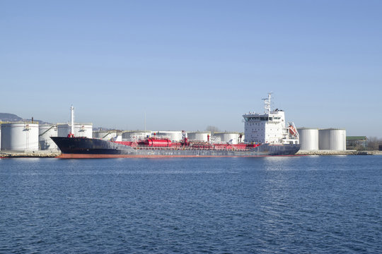 Big metal industrial oil tanks on port and  tanker