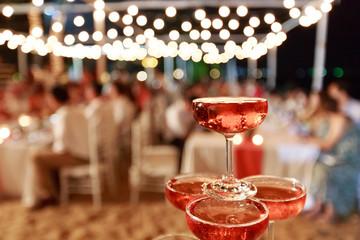 Pyramid from glasses of red wine on wedding party. Close-up of the pink champagne or wine pyramid...