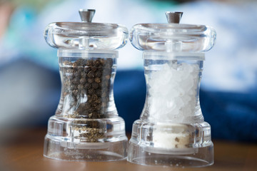 Glass salt and pepper shakers in restaurant.