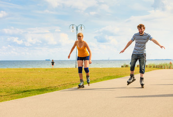 Obraz premium Young couple on roller skates riding outdoors