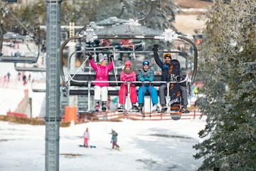 Happy family with ski lift climb up on ski terrain