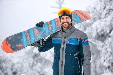 Man holding snowboard on ski terrain - obrazy, fototapety, plakaty