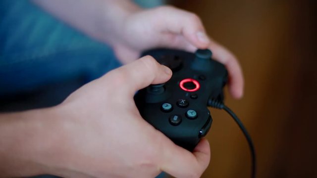 Young man playing on controller. Closeup shot.