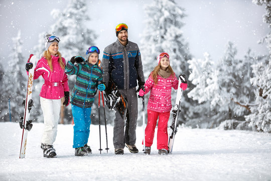 Family going to ski terrain with ski equipment