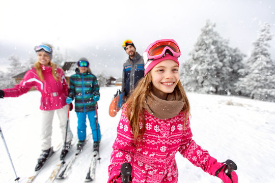 Girl skier skiing with family on mountain