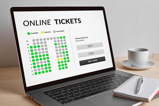 Online tickets concept on modern laptop computer screen on wooden table. All screen content is designed by me. 