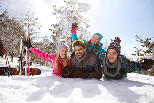 Family on winter vacation lying on snow and enjoy