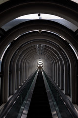 Diminishing perspective in a futuristic escalator tube, where does this tunnel bring us to?