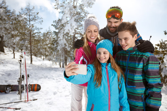 Girl taking selfie with family on skiing