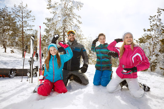 Family making snow balls on skiing in mountain