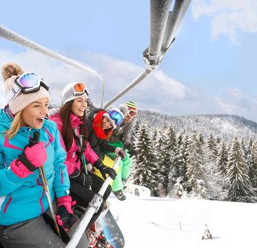  Happy skiers in ski lift lifting up on ski terrain
