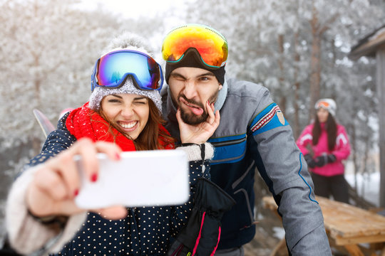 Skiers couple outdoor taking selfie.
