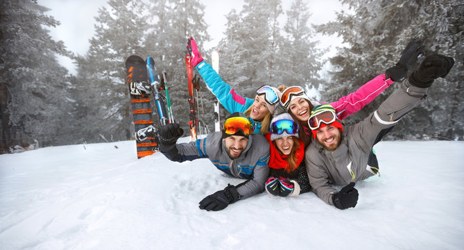Happy group of skiers lying on snow