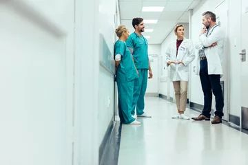 Fotobehang Team of doctors having discussion in hospital corridor © Jacob Lund