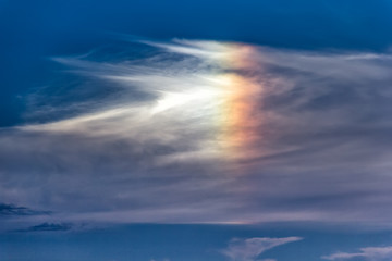 Beautiful cloudscape with a rainbow colorful cloud like a bird form