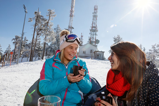 Young women drinking tea in cafe on skiing