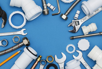 Plumbing tools and equipment overhead view on a blue background